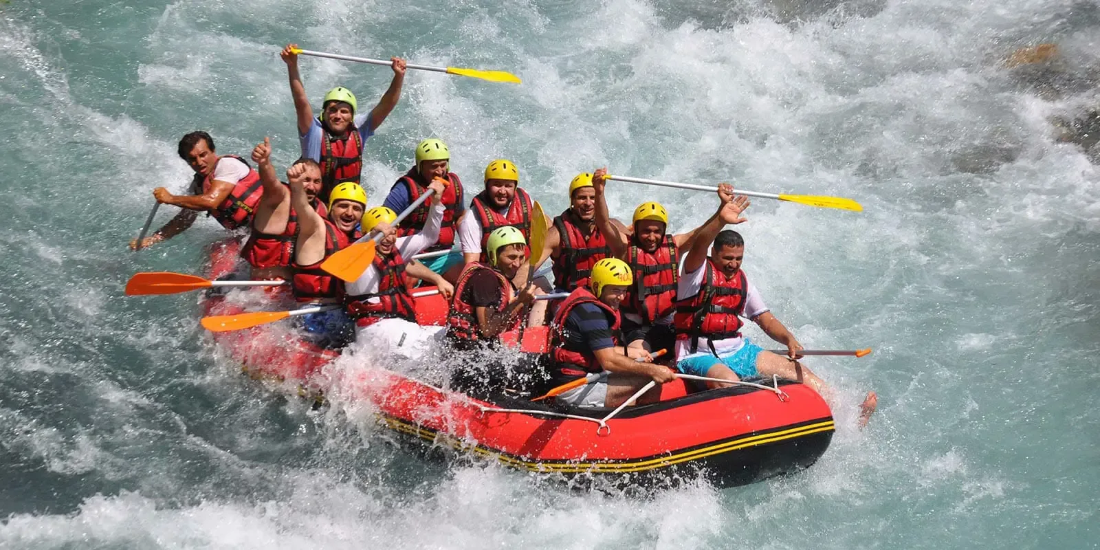 Crew riding the rapids in a red raft
