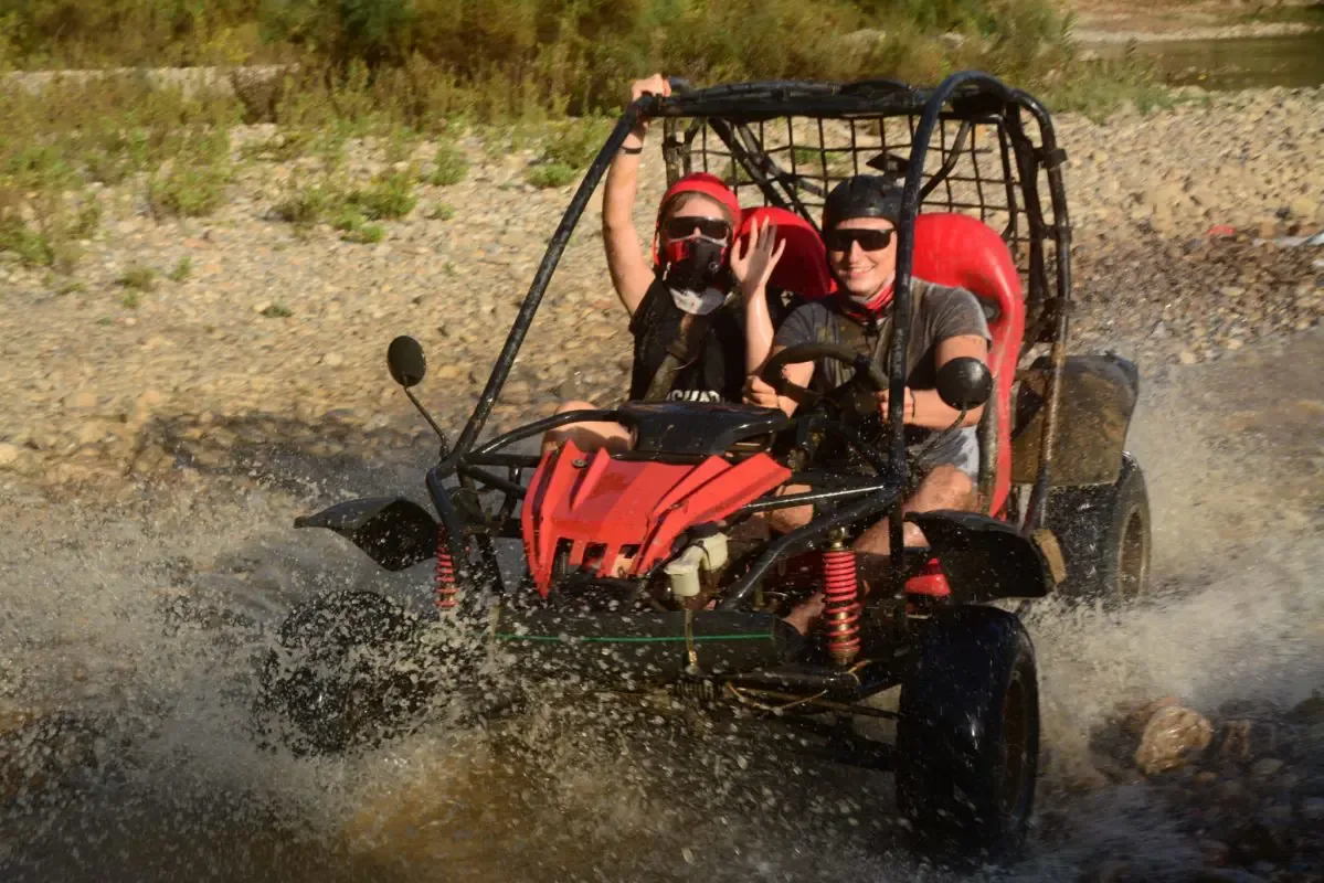 Su birikintisinden geçen kırmızı buggy